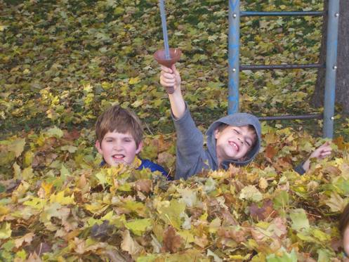 Joel and Micah up to their chins in leaves